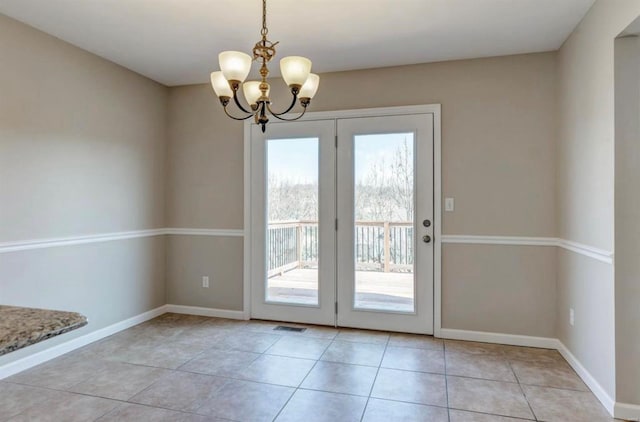 doorway featuring a chandelier, visible vents, baseboards, and light tile patterned flooring