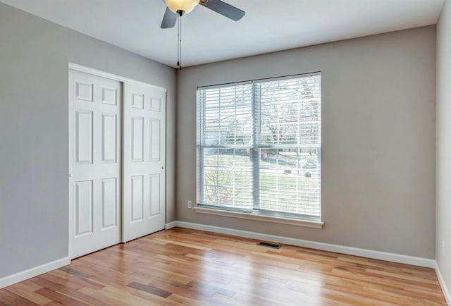 unfurnished bedroom featuring a closet, light wood-type flooring, visible vents, and baseboards