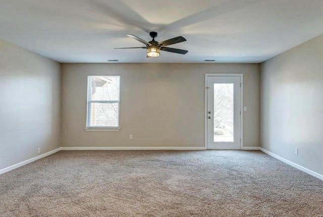 spare room with baseboards, carpet floors, and plenty of natural light