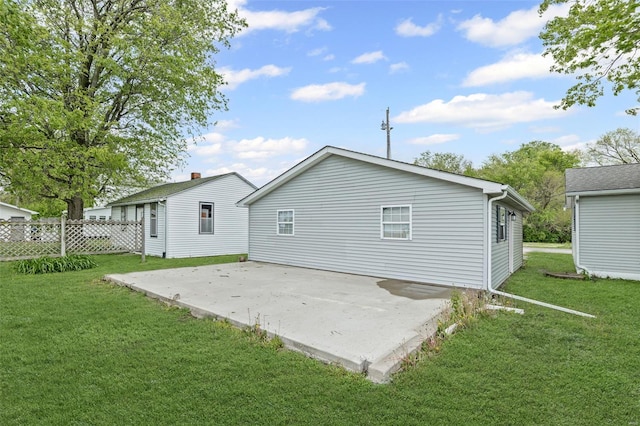 back of property with a patio, fence, and a yard