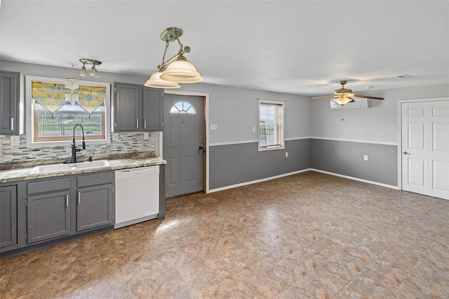 kitchen featuring a sink, ceiling fan, gray cabinets, baseboards, and dishwasher