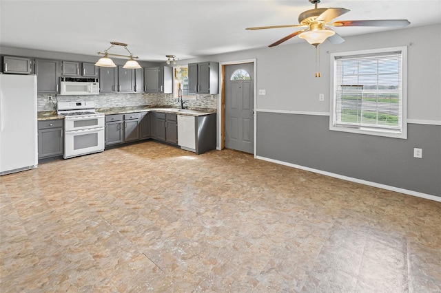 kitchen with gray cabinets, white appliances, decorative backsplash, baseboards, and a ceiling fan