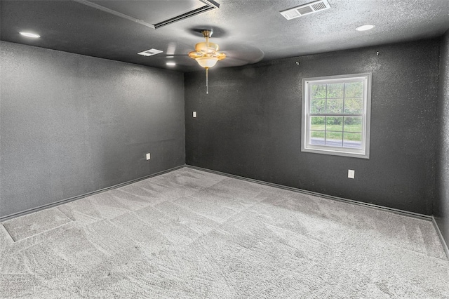 spare room featuring attic access, visible vents, ceiling fan, and carpet