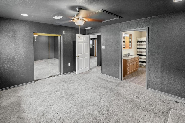 unfurnished bedroom with carpet floors, a textured ceiling, a closet, and a textured wall