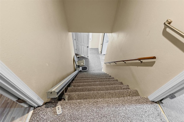 stairway featuring a textured wall