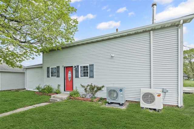 back of property with a lawn and ac unit