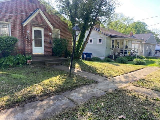 view of front of home with brick siding and a front yard
