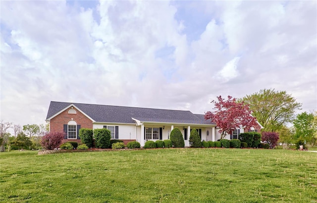 view of front of house featuring brick siding and a front yard