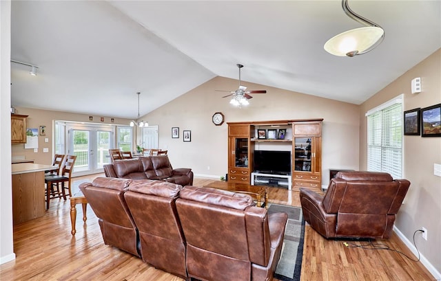 living room with baseboards, a ceiling fan, light wood-style flooring, and vaulted ceiling