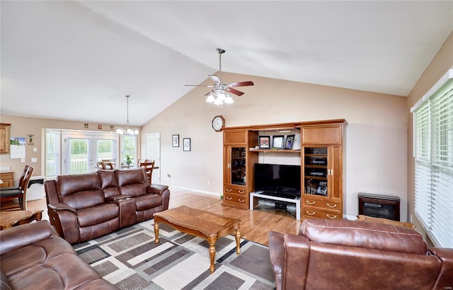living area featuring baseboards, light wood-style flooring, high vaulted ceiling, and ceiling fan with notable chandelier