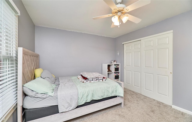 carpeted bedroom featuring baseboards, a ceiling fan, and a closet