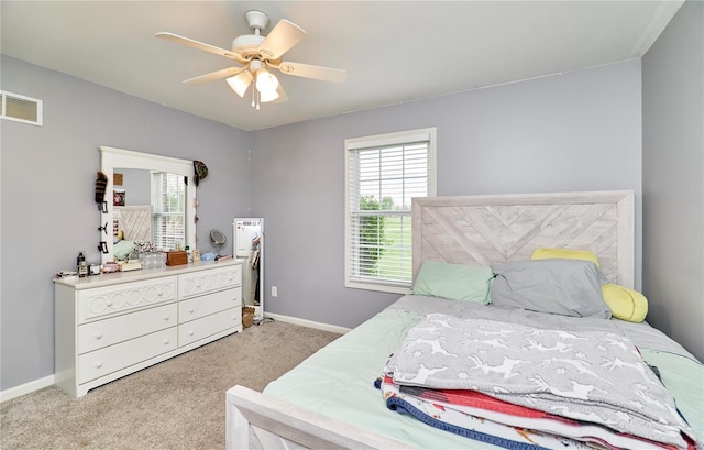 bedroom featuring multiple windows, baseboards, light colored carpet, and visible vents