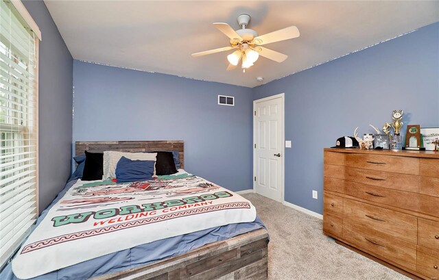 carpeted bedroom with visible vents, a ceiling fan, and baseboards