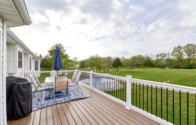 deck featuring a lawn, outdoor dining space, and grilling area
