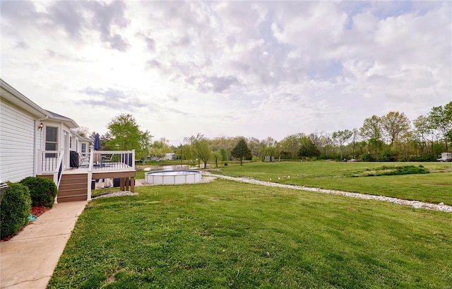view of yard featuring a deck and an outdoor pool