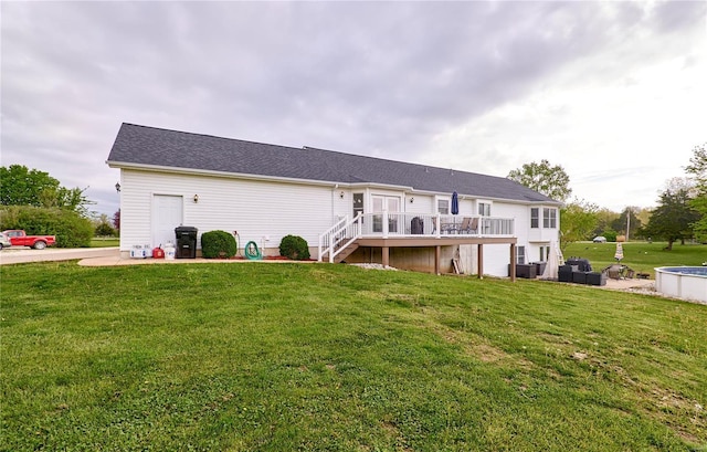 rear view of property featuring a lawn, stairs, and a wooden deck