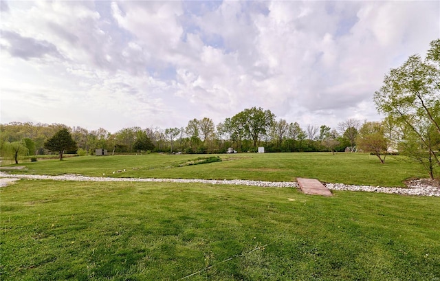 view of community with a lawn and a rural view