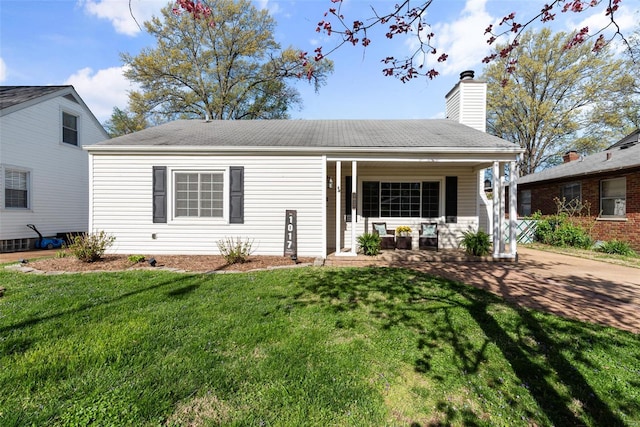 bungalow-style house featuring a chimney, a front yard, and covered porch