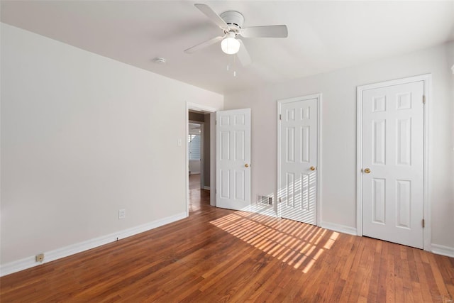 unfurnished bedroom featuring wood finished floors, baseboards, a closet, and ceiling fan
