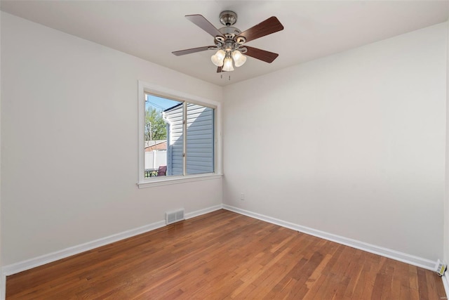 empty room featuring baseboards, wood finished floors, visible vents, and a ceiling fan
