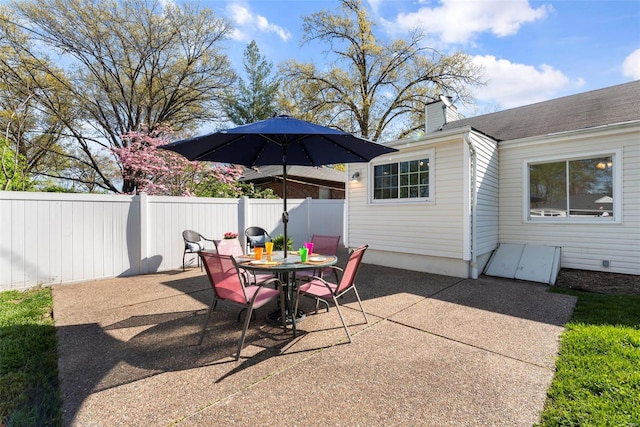 view of patio featuring outdoor dining space and fence