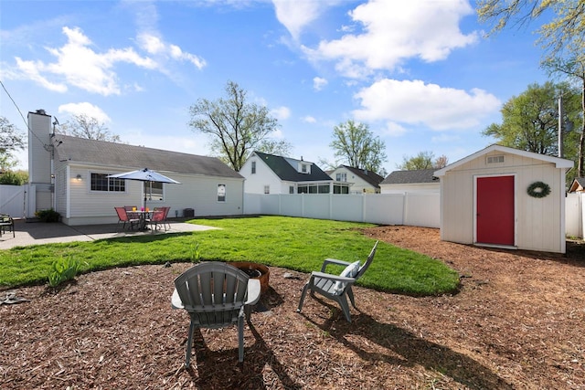 view of yard with a fenced backyard, a storage unit, an outbuilding, and a patio