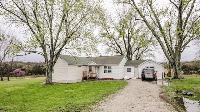 ranch-style house with a garage, driveway, and a front lawn