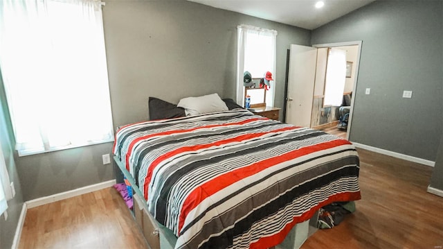 bedroom with wood finished floors, baseboards, and recessed lighting