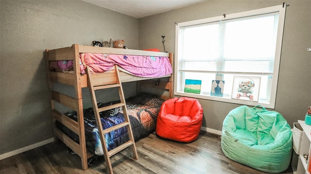 bedroom featuring baseboards and wood finished floors