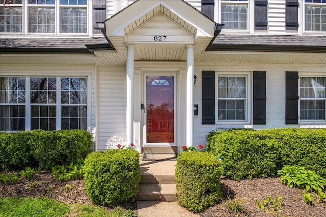 property entrance featuring a shingled roof