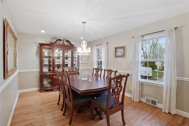 dining room with a chandelier, visible vents, a healthy amount of sunlight, and light wood-style flooring