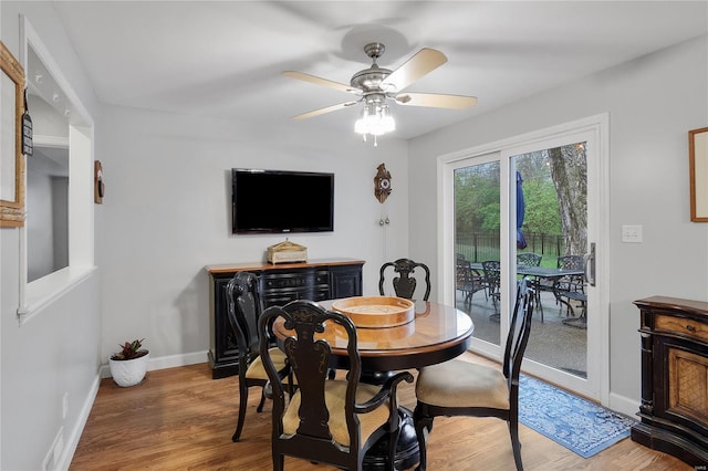 dining space featuring baseboards, a ceiling fan, and wood finished floors