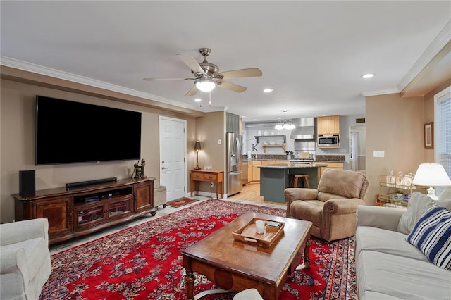 living area featuring light wood finished floors, ornamental molding, recessed lighting, and ceiling fan with notable chandelier