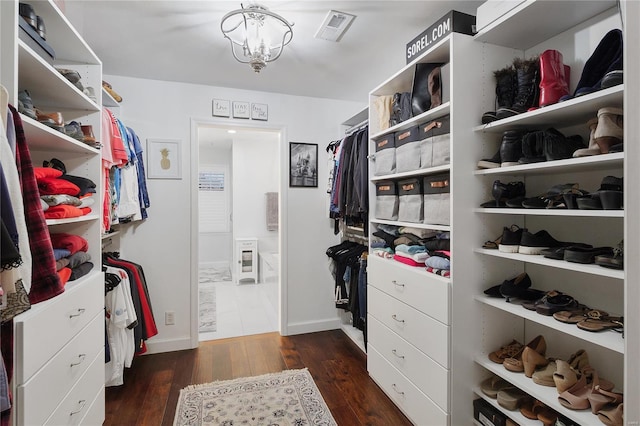 spacious closet featuring a chandelier, dark wood-style floors, and visible vents