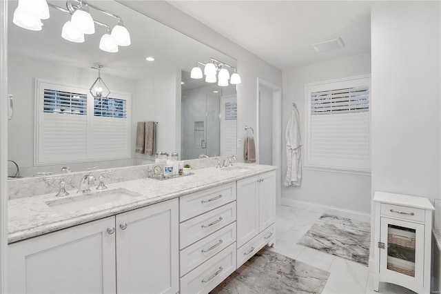 bathroom featuring a chandelier, marble finish floor, a sink, and a stall shower