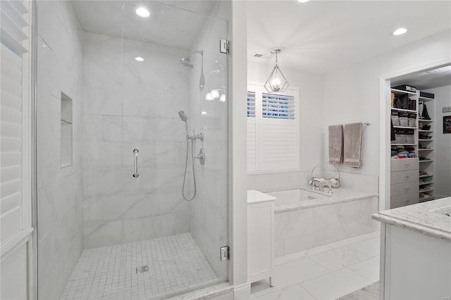 bathroom with a bath, a stall shower, a spacious closet, and recessed lighting