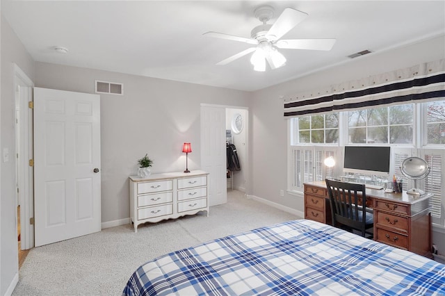 carpeted bedroom with visible vents, baseboards, and a ceiling fan