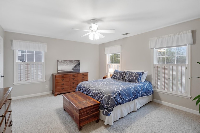 carpeted bedroom with visible vents, baseboards, and a ceiling fan