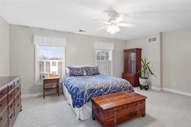 bedroom with visible vents, multiple windows, and light carpet