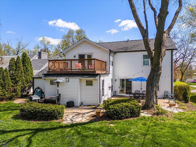 back of house featuring a patio area, a wooden deck, a yard, and roof with shingles