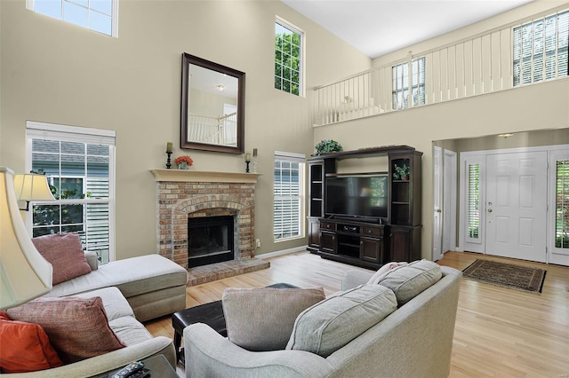 living room featuring a high ceiling, wood finished floors, and a fireplace