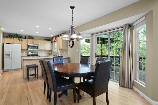dining area with light wood-type flooring, recessed lighting, baseboards, and an inviting chandelier