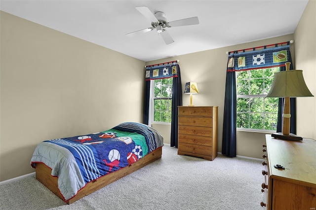 carpeted bedroom with baseboards, multiple windows, and ceiling fan