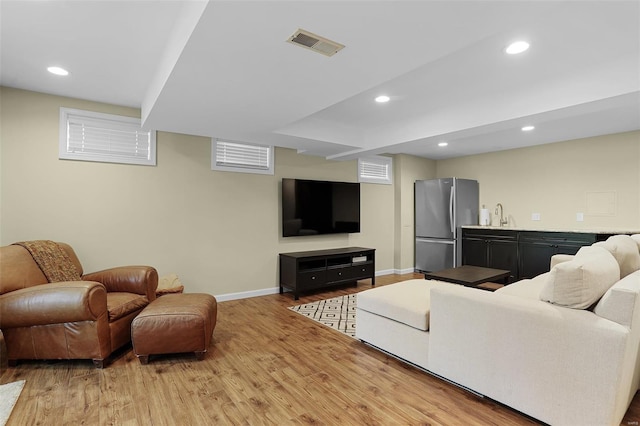 living area with baseboards, recessed lighting, wood finished floors, and visible vents