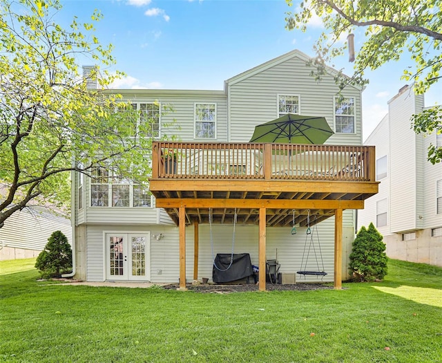 rear view of property featuring a lawn, french doors, and a wooden deck