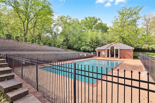 community pool with fence and a patio