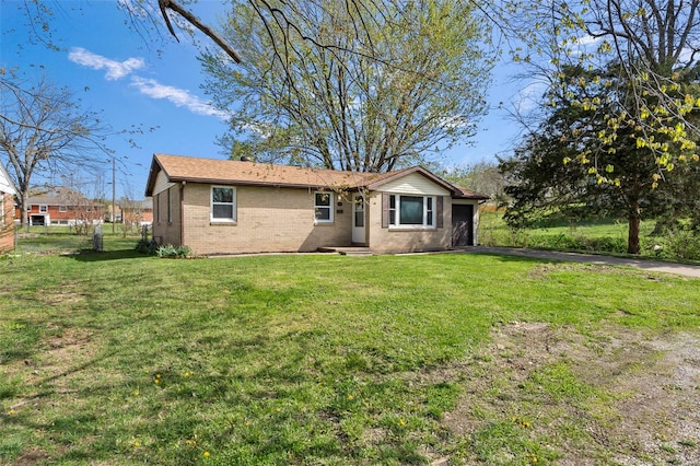 view of front of property with brick siding, a front lawn, an attached garage, and driveway