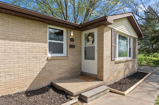 doorway to property featuring brick siding