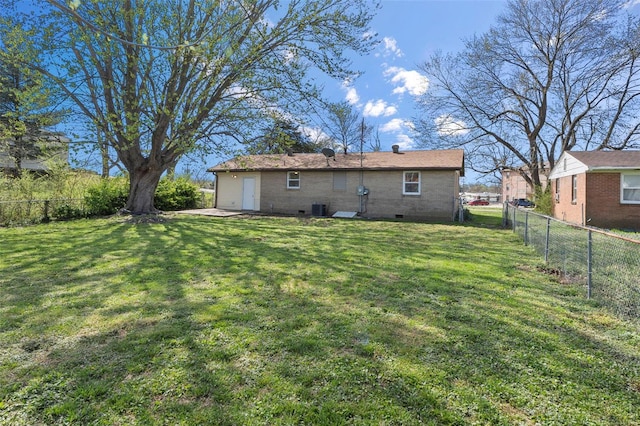 back of property with a fenced backyard and a lawn