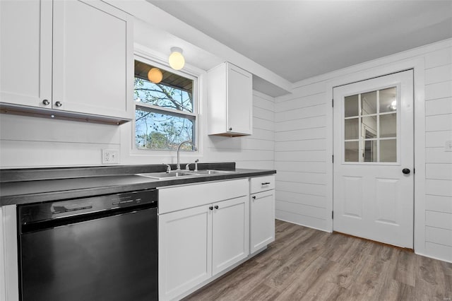 kitchen featuring white cabinets, dishwasher, a sink, light wood-type flooring, and dark countertops